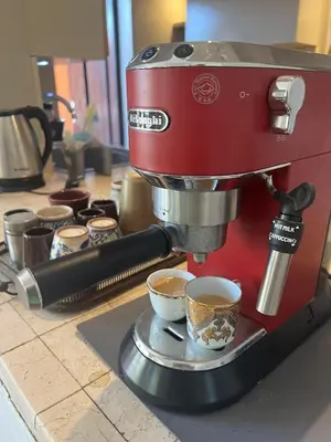a red coffee machine sitting on a counter with cups of coffee at El Gouna Nubian Lagoonfront Villa - 4BR, 9 Guests in El Gouna