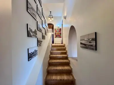 a hallway with a stairway with pictures on the wall at El Gouna Nubian Lagoonfront Villa - 4BR, 9 Guests in El Gouna