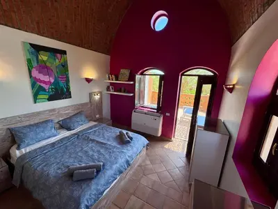 a bedroom with a large bed with purple walls at El Gouna Nubian Lagoonfront Villa - 4BR, 9 Guests in El Gouna