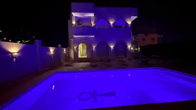a house with a swimming pool at night at Magic Garden House in Luxor