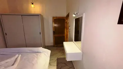 a bedroom with a bed and a mirror on the wall at Villa Hofni in Luxor