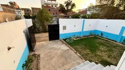 a small backyard with a blue and white fence at Villa Hofni in Luxor