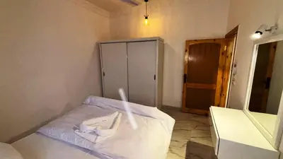 a bedroom with a white bed and a cabinet at Villa Hofni in Luxor