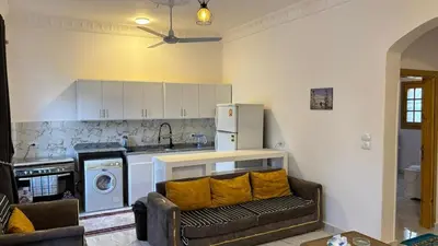 a living room with a couch and a kitchen at Villa Hofni in Luxor
