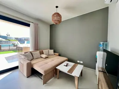 a living room with a couch and a table at Makadi Heights Luxury 1-BR App with Garden & Lagoon View in Hurghada