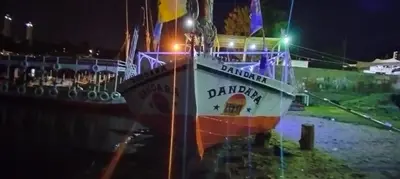 a boat sitting in the water at night at دندرة بوت in Aswān