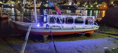 a boat sitting in the water at night at دندرة بوت in Aswān