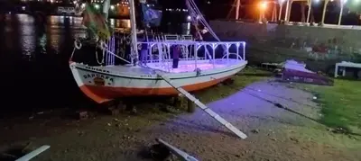 a boat sitting on the shore of the water at night at دندرة بوت in Aswān