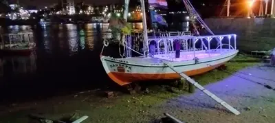 a boat is docked in the water at night at دندرة بوت in Aswān