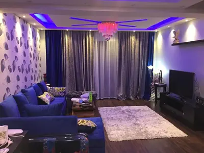 a living room with a blue couch and a tv at The view in Hurghada