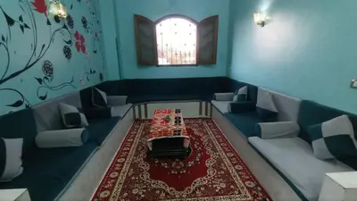 a room with a table and couches and a window at Relaxing Lodge in Luxor in ‘Ezbet Abu Ḥabashi