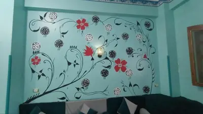 a wall with a mural of flowers on a wall at Relaxing Lodge in Luxor in ‘Ezbet Abu Ḥabashi