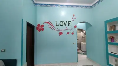 a room with a blue wall with a sign that says love at Relaxing Lodge in Luxor in ‘Ezbet Abu Ḥabashi