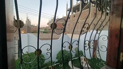 a gate with a view of a city behind it at Relaxing Lodge in Luxor in ‘Ezbet Abu Ḥabashi