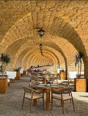 a restaurant with tables and chairs under an archway at EDElma in Hurghada