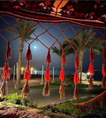 a group of red tassels hanging from palm trees at EDElma in Hurghada