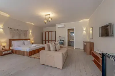 a bedroom with a bed and a couch and a television at Soulful Studio in Bali El Gouna in Hurghada