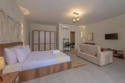 a bedroom with a bed and a couch and a chair at Soulful Studio in Bali El Gouna in Hurghada