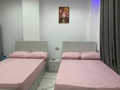 two beds in a room with pink sheets at منتجع اوسيس مارينا in Hurghada