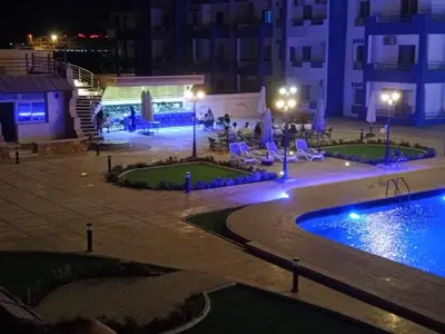 a swimming pool in a courtyard at night at منتجع اوسيس مارينا in Hurghada
