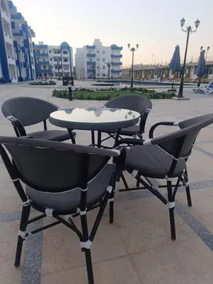 three chairs and a table in a courtyard at منتجع اوسيس مارينا in Hurghada