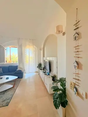 a living room with a blue couch and a tv at El Gouna Stylish 2BR Italian Compound Beach Access in Hurghada