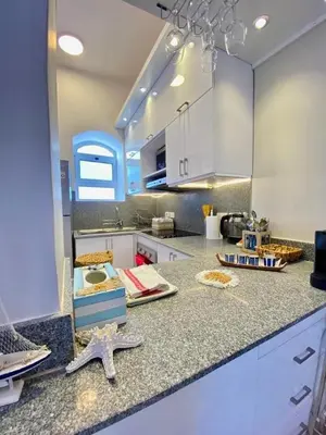 a kitchen with white cabinets and a starfish on a counter at El Gouna Stylish 2BR Italian Compound Beach Access in Hurghada