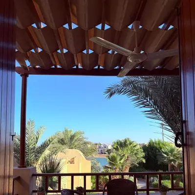 a patio with a view of the ocean and palm trees at El Gouna Stylish 2BR Italian Compound Beach Access in Hurghada