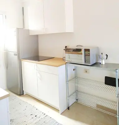 a small kitchen with white cabinets and a microwave at Bay breeze in Hurghada