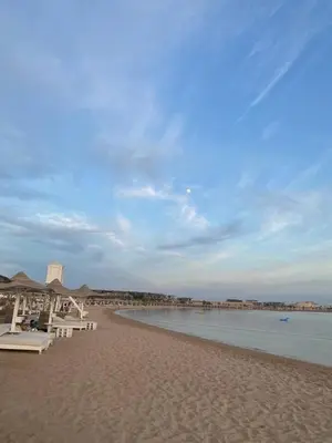a sandy beach with tables and chairs and the water at Bay breeze in Hurghada