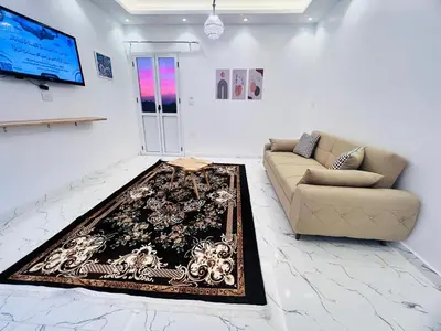 a living room with a couch and a rug on the floor at Muhammad Ali house in Luxor
