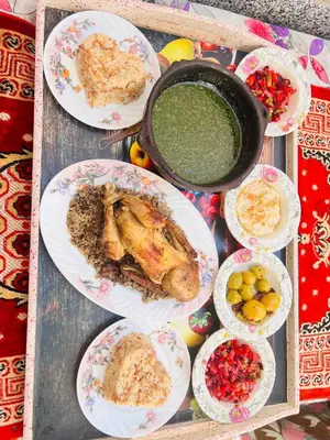 a table with plates of food and a pot of soup at Muhammad Ali house in Luxor