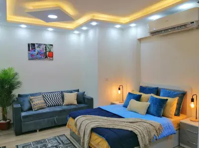 a bedroom with a blue bed and a couch at Luxury apartment With sea view and free beach in Hurghada