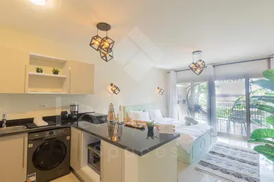 a living room with a kitchen and a bed at Ladybird - Veranda Loft in Hurghada