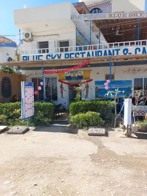 a building with a sign that reads in the city department of pain at Blue Sky Apartments & Restaurant in Luxor