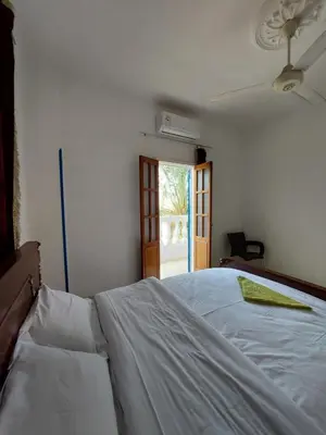 a white bed in a room with a window at Blue Sky Apartments & Restaurant in Luxor