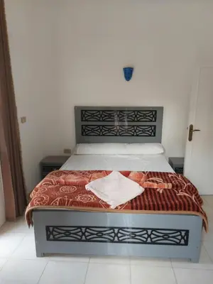 a bedroom with a bed with a red blanket at Blue Sky Apartments & Restaurant in Luxor