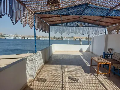 a patio with a view of the water at Blue Sky Apartments & Restaurant in Luxor