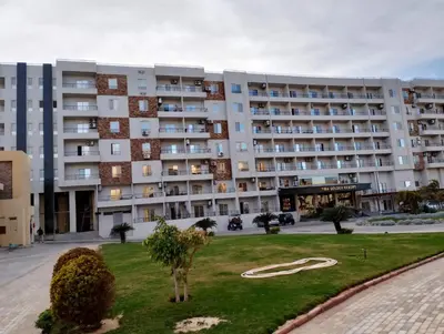 a large building with a lawn in front of it at Tiba Golden in Hurghada