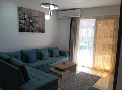 a living room with a blue couch and a window at Tiba Golden in Hurghada