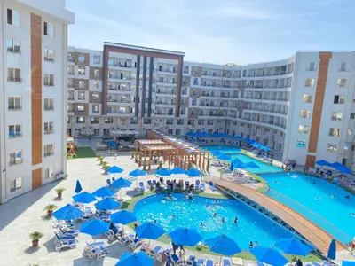 an aerial view of a swimming pool with blue umbrellas at Tiba Golden in Hurghada