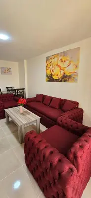 a living room with two red couches and a table at Tiba golden resort hurghada holiday in Hurghada
