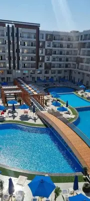 a large hotel with a large pool with umbrellas at Tiba golden resort hurghada holiday in Hurghada