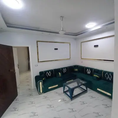 a living room with a green couch and a table at Villa Nicole in Luxor