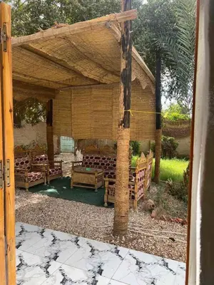 a wooden pergola with chairs under it at Djorff studio in Al Aqālitah