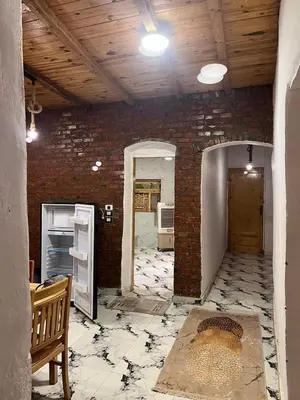 an empty room with a brick wall and a room with a table at Djorff studio in Al Aqālitah