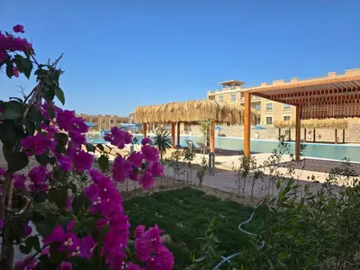 a resort with a swimming pool and purple flowers at Bay View Resort in Hurghada