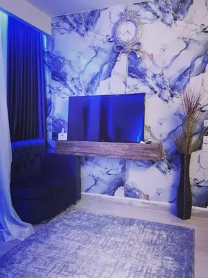 a living room with a tv on a blue wall at Bay View Resort in Hurghada