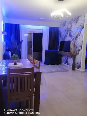a living room with a dining table and a blue room at Bay View Resort in Hurghada