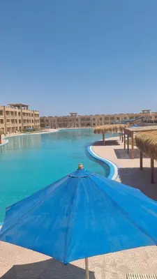 a blue umbrella sitting next to a swimming pool at Bay View Resort in Hurghada